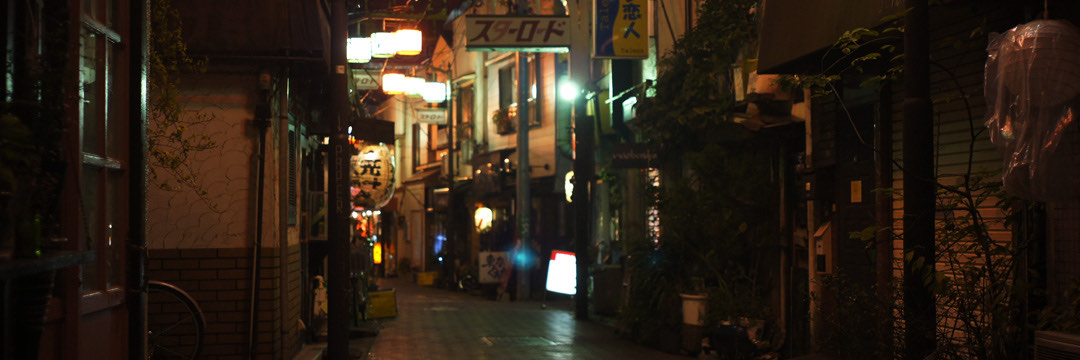 夜の阿佐ヶ谷の路地。連なる看板と提灯の灯り